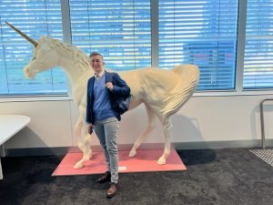 Nicole stands in front of a statue of a unicorn